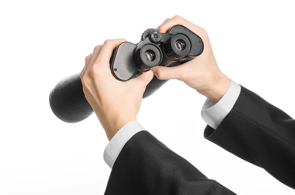 Business and search topic: Man in black suit holding a black binoculars in hand on white isolated background in studio — 스톡 사진