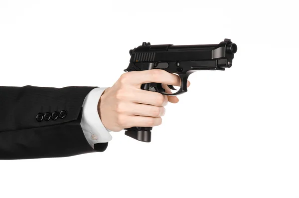 Firearms and security topic: a man in a black suit holding a gun on an isolated white background in studio — Stok fotoğraf