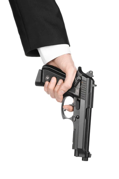 Firearms and security topic: a man in a black suit holding a gun on an isolated white background in studio — Stok fotoğraf