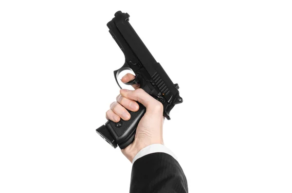 Firearms and security topic: a man in a black suit holding a gun on an isolated white background in studio — Stok fotoğraf