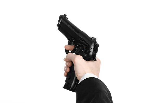 Firearms and security topic: a man in a black suit holding a gun on an isolated white background in studio — 图库照片