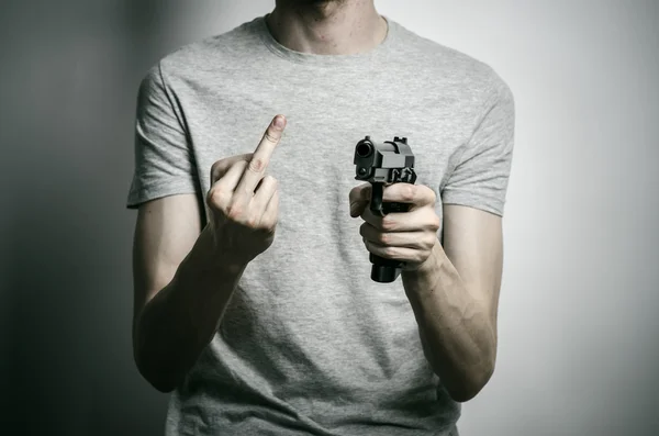 Horror and firearms topic: suicide with a gun on a gray background in the studio — 스톡 사진