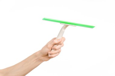 Household cleaning and washing windows theme: man's hand holding a green scraper windows isolated on a white background in the studio.