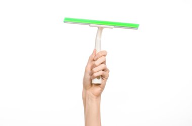 Household cleaning and washing windows theme: man's hand holding a green scraper windows isolated on a white background in the studio.