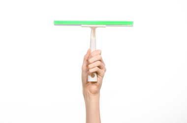 Household cleaning and washing windows theme: man's hand holding a green scraper windows isolated on a white background in the studio.