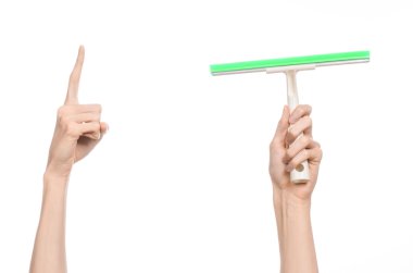 Household cleaning and washing windows theme: man's hand holding a green scraper windows isolated on a white background in the studio.