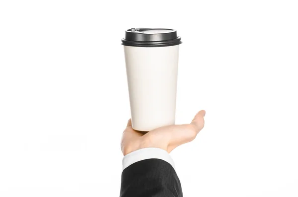 Business lunches coffee theme: businessman in a black suit holding a white blank paper cup of coffee with a brown plastic cap isolated on a white background in the studio, advertising coffee — Stockfoto