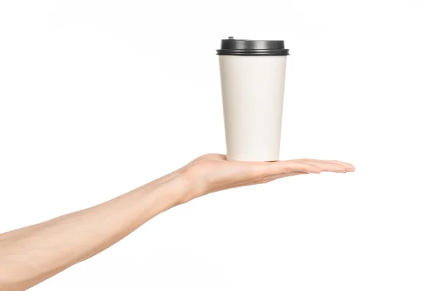 Ontbijt en koffie thema: de hand van de man met witte lege papieren koffiebeker met een bruine plastic dop geïsoleerd op een witte achtergrond in de studio, reclame voor koffie — Stockfoto