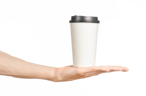 Reggeli és kávé téma: férfi kéz kezében fehér üres papír kávéscsésze barna műanyag kupakkal elszigetelt fehér háttér a stúdióban, reklám kávé — Stock Fotó