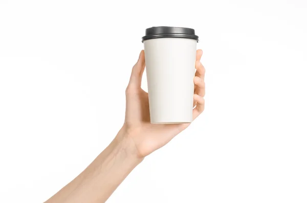Desayuno y café tema: la mano del hombre sosteniendo blanco taza de café de papel vacío con una tapa de plástico marrón aislado sobre un fondo blanco en el estudio, publicidad de café — Foto de Stock