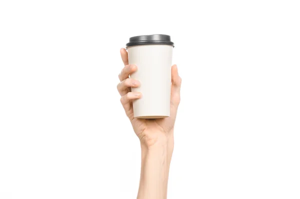 Frukost och kaffe tema: mannens hand håller vitt tomt papper kaffekopp med en brun plast mössa isolerad på en vit bakgrund i studion, reklam kaffe — Stockfoto