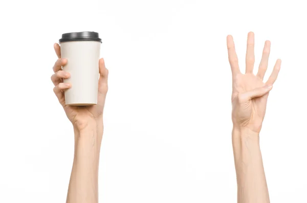 Frukost och kaffe tema: mannens hand håller vitt tomt papper kaffekopp med en brun plast mössa isolerad på en vit bakgrund i studion, reklam kaffe — Stockfoto