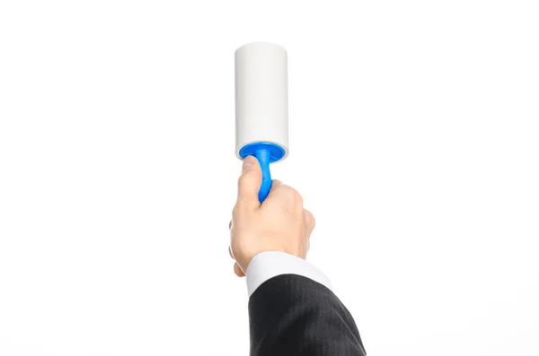 Dry cleaning and business theme: a man in a black suit holding a blue sticky brush for cleaning clothes and furniture from dust isolated on white background in studio. — ストック写真