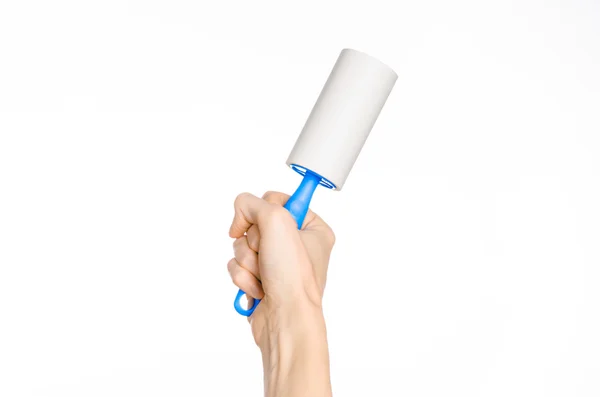 Clean clothes and cleaning the house topic: human hand holding a blue sticky brush for cleaning clothes and furniture from dust isolated on white background in studio. — Stock fotografie