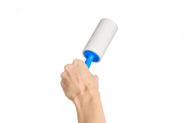 Pulire i vestiti e pulire il tema della casa: mano umana in possesso di un pennello blu appiccicoso per la pulizia di vestiti e mobili da polvere isolata su sfondo bianco in studio . — Foto Stock
