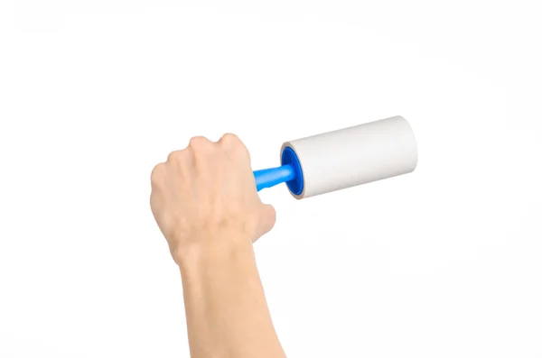 Clean clothes and cleaning the house topic: human hand holding a blue sticky brush for cleaning clothes and furniture from dust isolated on white background in studio. — ストック写真