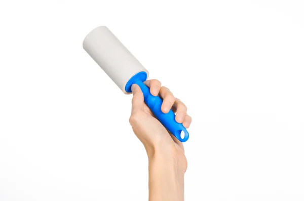 Clean clothes and cleaning the house topic: human hand holding a blue sticky brush for cleaning clothes and furniture from dust isolated on white background in studio. — Stockfoto