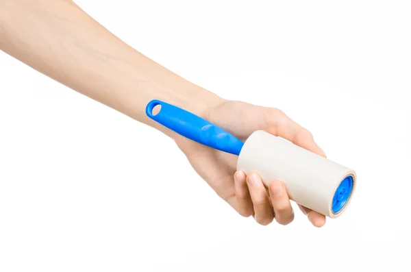 Clean clothes and cleaning the house topic: human hand holding a blue sticky brush for cleaning clothes and furniture from dust isolated on white background in studio. — 图库照片