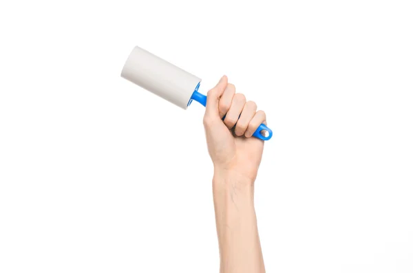 Clean clothes and cleaning the house topic: human hand holding a blue sticky brush for cleaning clothes and furniture from dust isolated on white background in studio. — Stok fotoğraf