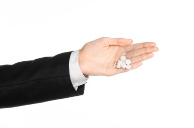 Addiction and business topic: hand in a black suit holds bag with white pills a drug on a white isolated background in studio