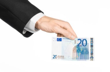 Money and business topic: hand in a black suit holding a banknote 20 euro isolated on a white background in studio