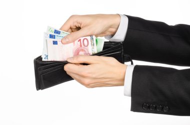 Money and business topic: hand in a black suit holding a wallet with banknotes 10,20 and 100 euro on white isolated background in studio