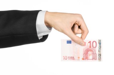 Money and business topic: hand in a black suit holding a banknote 10 euro isolated on a white background in studio