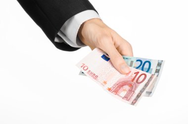 Money and business topic: hand in a black suit holding banknotes 10 and 20 euro on white isolated background in studio