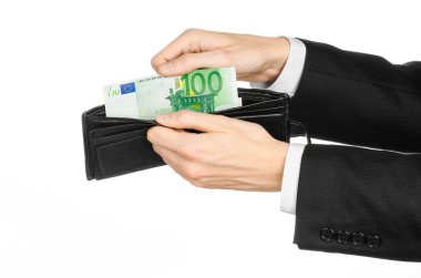 Money and business topic: hand in a black suit holding a wallet with 100 euro banknotes isolated on white background in studio