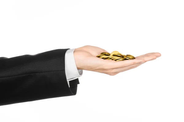 Dinheiro e tópico de negócios: mão em um terno preto segurando uma pilha de moedas de ouro no estúdio em um fundo branco isolado — Fotografia de Stock