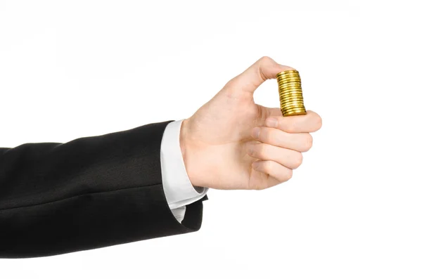 Geld und Geschäftsthema: Hand in schwarzem Anzug mit einem Stapel Goldmünzen im Atelier auf weißem Hintergrund — Stockfoto