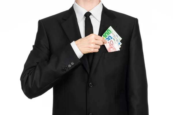 Money and business theme: a man in a black suit is holding euro money isolated on white background in studio — 스톡 사진