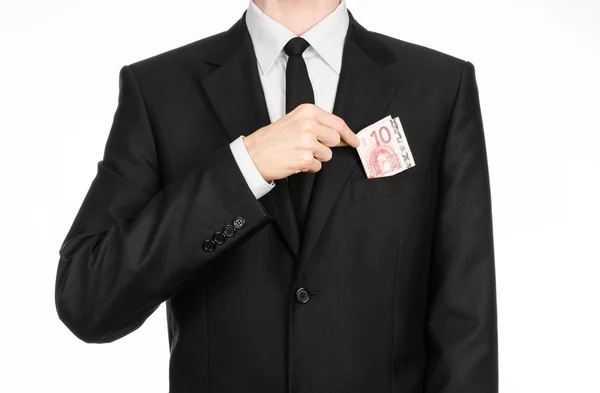Money and business theme: a man in a black suit holding a bill of 10 euros and shows a hand gesture on an isolated white background in studio — 스톡 사진