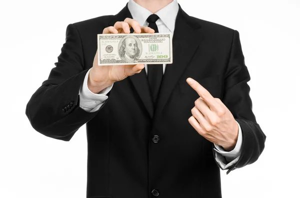 Dinero y tema de negocios: un hombre con un traje negro con un billete de 100 dólares y cuenta con un gesto de mano sobre un fondo blanco aislado en el estudio — Foto de Stock