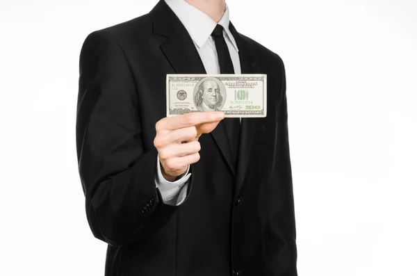 Dinheiro e tema de negócios: um homem de terno preto segurando uma nota de 100 dólares e apresenta um gesto de mão em um fundo branco isolado em estúdio — Fotografia de Stock