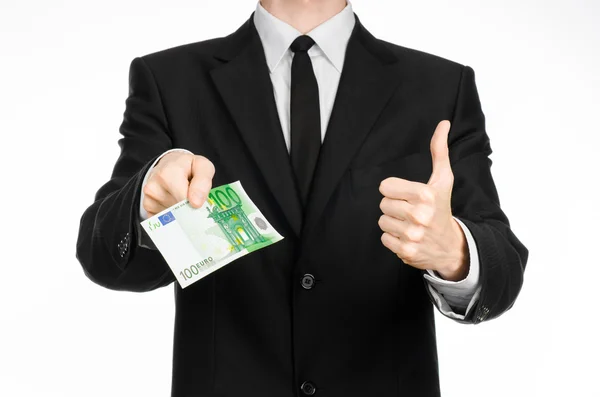 Tema dinero y negocios: un hombre de traje negro con un billete de 100 euros y muestra un gesto de mano sobre un fondo blanco aislado en el estudio — Foto de Stock
