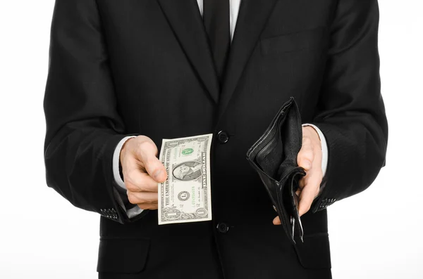 Poverty and money theme: a man in a black suit holding a empty wallet and banknote 1 dollar on white isolated background in studio — 图库照片
