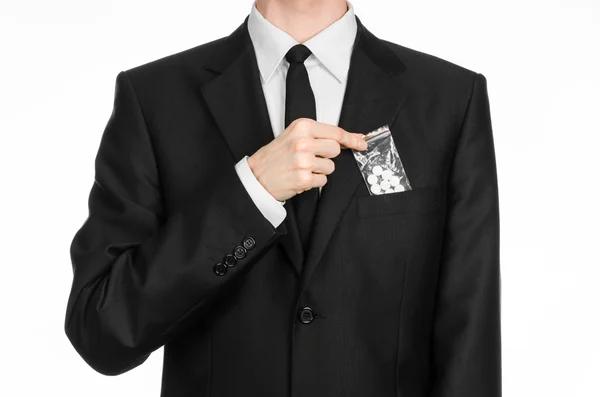 Addiction and business topic: hand in a black suit holds bag with white pills a drug on a white isolated background in studio — 스톡 사진