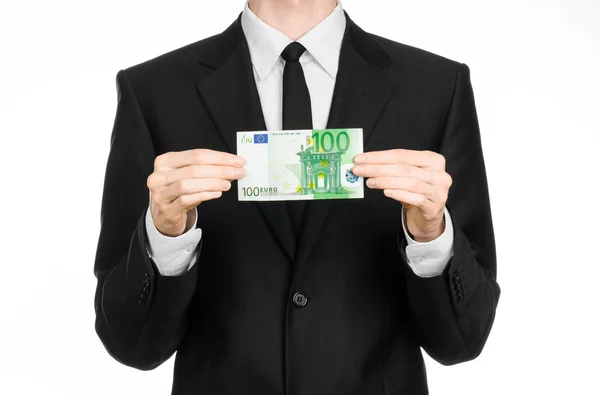 Dinheiro e tema de negócios: um homem de terno preto segurando uma nota de 100 euros e mostra um gesto de mão em um fundo branco isolado em estúdio — Fotografia de Stock