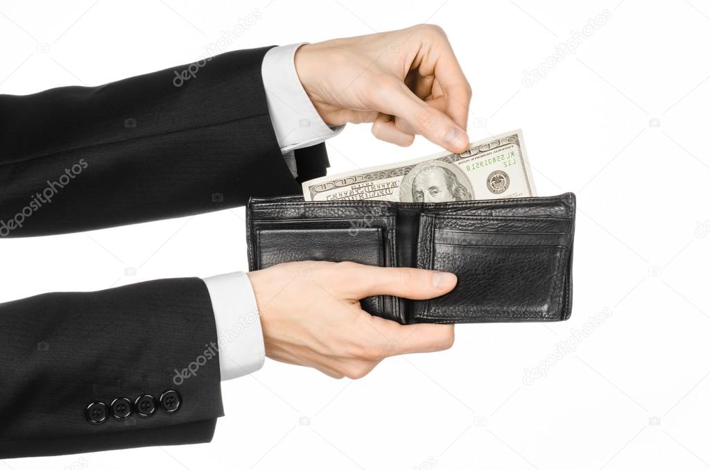 Money and business topic: hand in a black suit holding a wallet with dollar banknotes isolated on white background in studioMoney and business topic: hand in a black suit holding a wallet with dollar