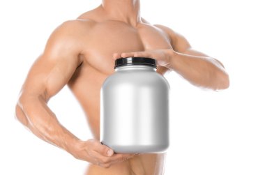 Bodybuilding and Sports theme: handsome strong bodybuilder holding a plastic jar with a dry protein and showing gesture isolated on white background in studio