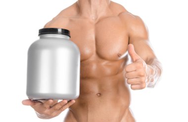 Bodybuilding and Sports theme: handsome strong bodybuilder holding a plastic jar with a dry protein and showing gesture isolated on white background in studio
