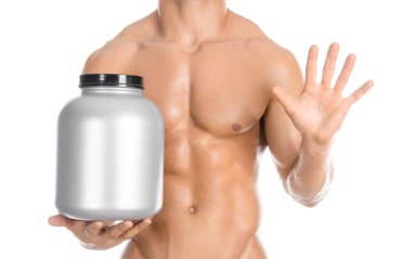 Bodybuilding and Sports theme: handsome strong bodybuilder holding a plastic jar with a dry protein and showing gesture isolated on white background in studio