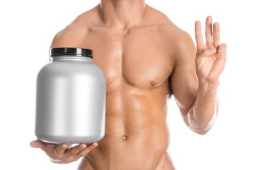 Bodybuilding and Sports theme: handsome strong bodybuilder holding a plastic jar with a dry protein and showing gesture isolated on white background in studio