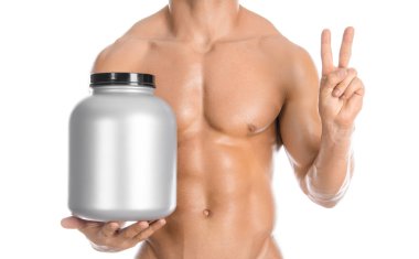 Bodybuilding and Sports theme: handsome strong bodybuilder holding a plastic jar with a dry protein and showing gesture isolated on white background in studio