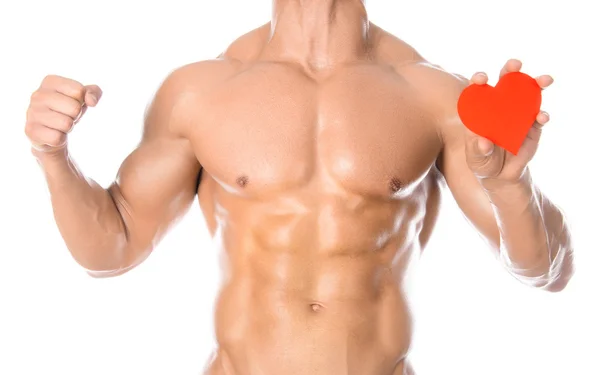 Testépítés és egészség: jóképű erős testépítő kezében egy papír kártya piros szív elszigetelt fehér alapon stúdió — Stock Fotó
