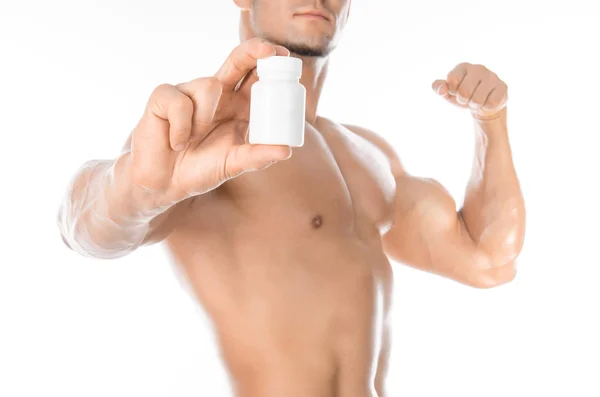 Бодібілдінг і хімічні добавки: красивий сильний культурист тримає білу банку таблеток на білому ізольованому фоні в студії — стокове фото
