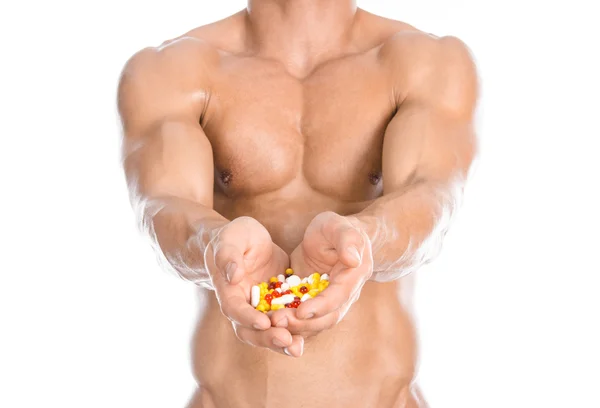 Bodybuilding and chemical additives: handsome strong bodybuilder holding colored pills isolated on white background in studio — ストック写真