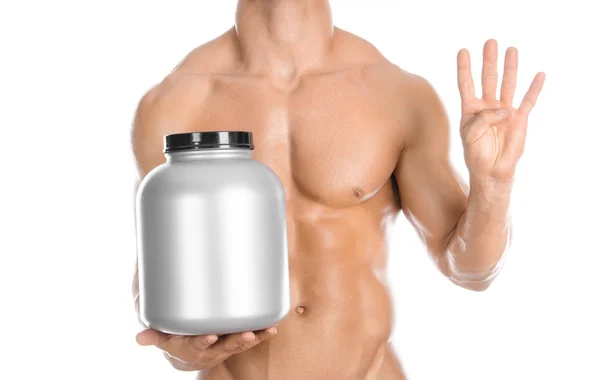 Tema culturismo e sport: bel bodybuilder forte che tiene in mano un barattolo di plastica con una proteina secca e mostra un gesto isolato su sfondo bianco in studio — Foto Stock