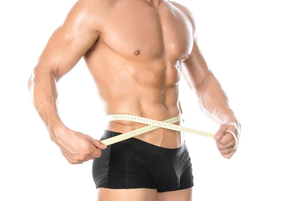 Bodybuilding and Sports theme: handsome strong bodybuilder holding centimeter tape to measure body isolated on white background in studio — 스톡 사진